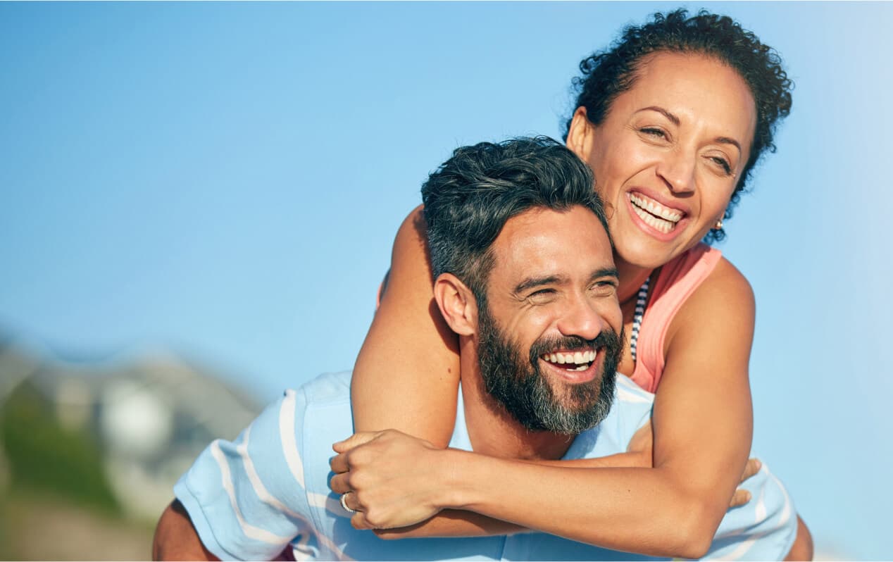 Two patients embracing and laughing outdoors