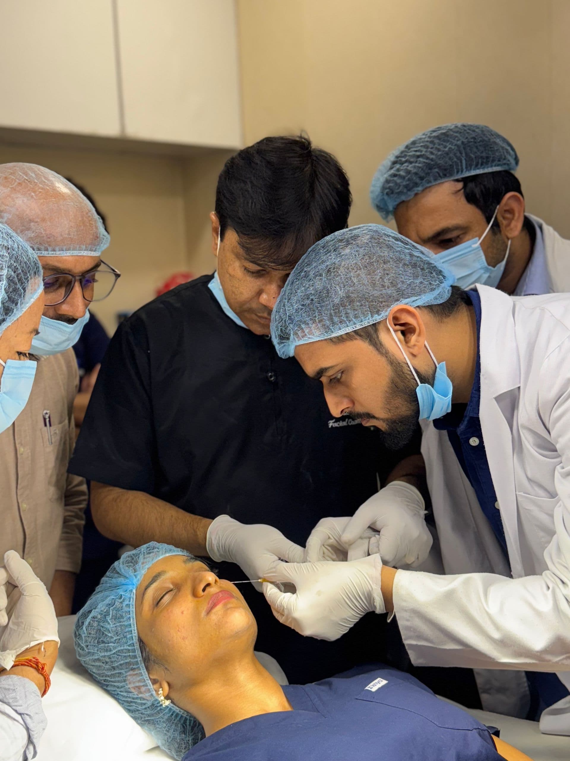 A clinical team performing a precise medical aesthetics treatment