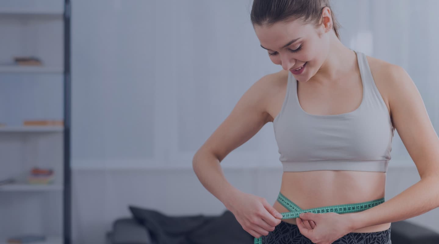 A patient measuring their waist during a body composition check