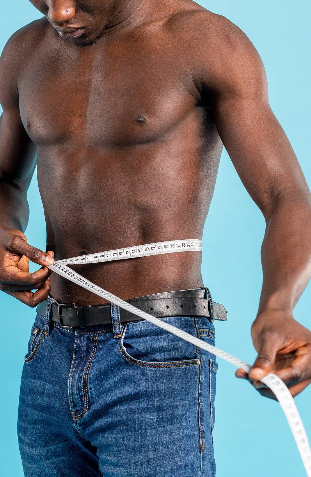 A man measuring his waist to track metabolic progress